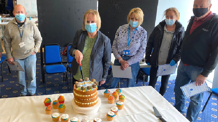 Vaccination volunteers cut their thank you cake.
