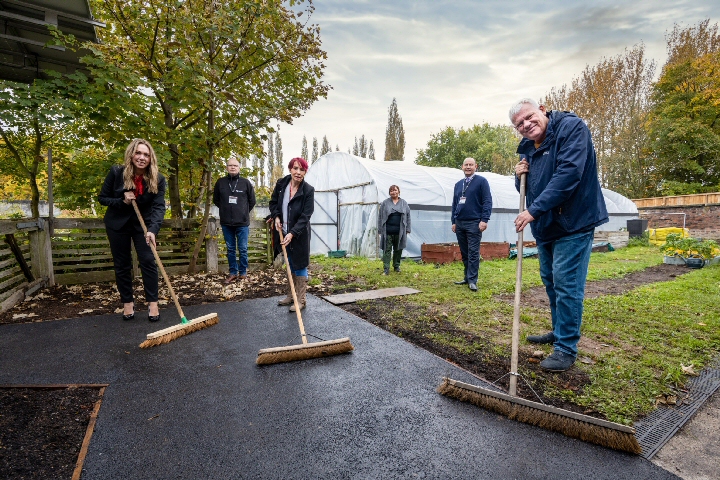 Amy Houlihan from Anwyl Homes (left) visits Incredible Edible Knowsley where funding from the homebuilder has helped improve footpaths.