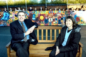St Philips C of E Primary Headteacher Brian Johnson and Community Foundation for Merseyside Grants Officer Joan Ford try out the new bench and enjoy the colourful mural.