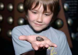 Visitor Callum holds a piece of the cosmos in the palm of his hand.
