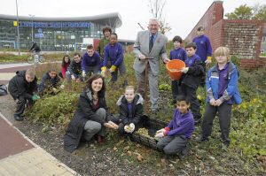 Cllr McGlashan (centre) children and volunteers create the wildflower garden