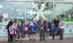 Staff and pupils from St Christopher’s Catholic Primary School join JLA’s Head of terminal Services, Dave Walsh (centre), following completion of their window display.
