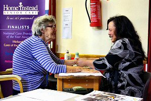 Information day attendee (left) receives hand massage from Home Instead owner Anthea Pilkington (right)