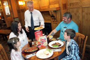 Richard Fearnley Smith, the new manager at The Stanley Arms in Huyton, serves dinner to the Hardy family.