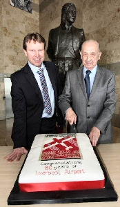 JLA CEO Matthew Thomas with Jim Keight, cutting the special anniversary cake which included the design from a poster used to promote the Airport Official opening event in 1933.