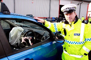 Sgt Paul Mountford with a car that had been involved in a crash.