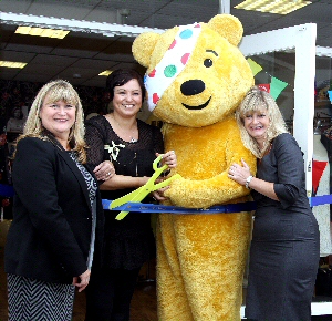 Pudsey Bear cuts the ribbon to announce Stick n Steps shop open (pictured left to right: Sarah Smithson, Operations Manager at Stick n Step, Liz Wood, New Crosby Shop Manager, Pudsey Bear, Kerry-Roe Ely, Community and Events Fundraiser at Stick n Step)