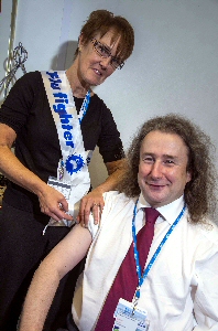 The deputy head of health and well-being Ann Cheetham giving Medical Director Mr Rob Gillies his flu vaccination