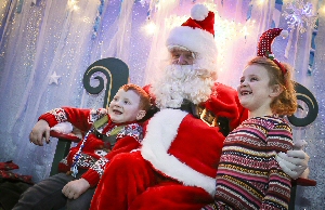 George Johnson is pictured with Santa Claus and his older sister Ava.