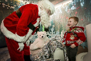 Santa Claus welcomes George to the grotto.