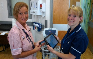 Health Care Assistant Angela Disley and Junior Sister Michelle Durney using VitalPAC on Ward H at Ormskirk hospital. 