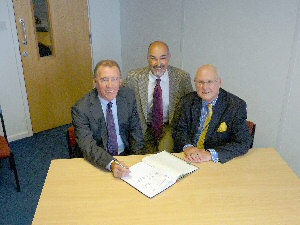 Picture shows Richard Fraser, chair of St Helens and Knowsley Teaching Hospitals NHS Trust, signing the pathology service agreement with Trust chair Sir Ron Watson CBE and Dr Paul Mansour, Trust Deputy Medical Director. 