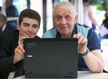 Photograph caption three: Stephen Moss, 13, helps Patrick Goodison get active online at Joseph Williams Mews. 