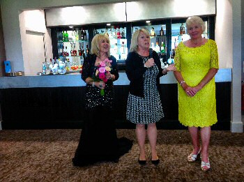 Julie A. Scott (singer) presented with flowers by the Lady Captain of Hillside Golf Club and Olive Cutts