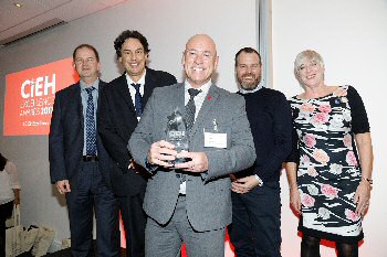 Pictured collecting the award are, from left to right, Ian Doig (Environmental Health), Gareth Hill (Public Health) and Jon Hardwick (Environmental Health) with Mark Byrne (from award sponsor, Grafton Empty Homes) and Ann Godfrey (Chief Executive of the CIEH). Please by Barney Newman