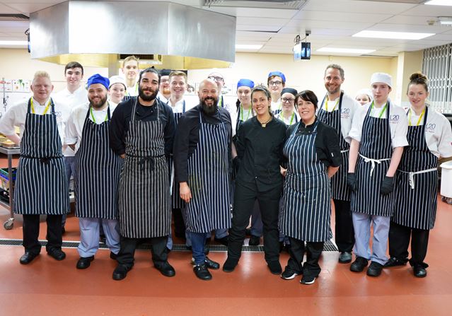 Photo shows chef Sean Paul Redding with his team and students and staff from the L20 Hotel School.