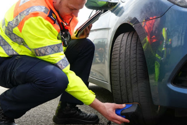 Highways England Traffic Officer Neil Waring, from Knutsford outstation, checking car tyres at 1 of Cheshire's charity car wash events in March 2018.