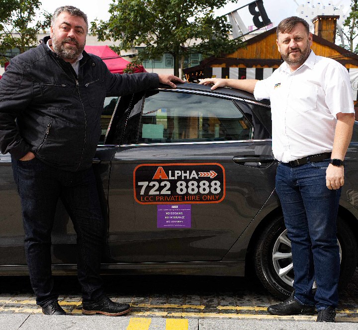 Liverpool City Councils Cabinet Member for Transport Cllr James Noakes shows off the new signs with Alpha Operations Manager Liam Sweeney.