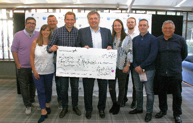 Liverpool City Center Lloyds Bank staff in group handing over the check Cheque. In the photo with Jan Molby are:- Phil Burton, James Fielding, Paul Convey, Damien Tilyer, Phil Nebb, Lucy Osborne, Joanne Mellitt, 