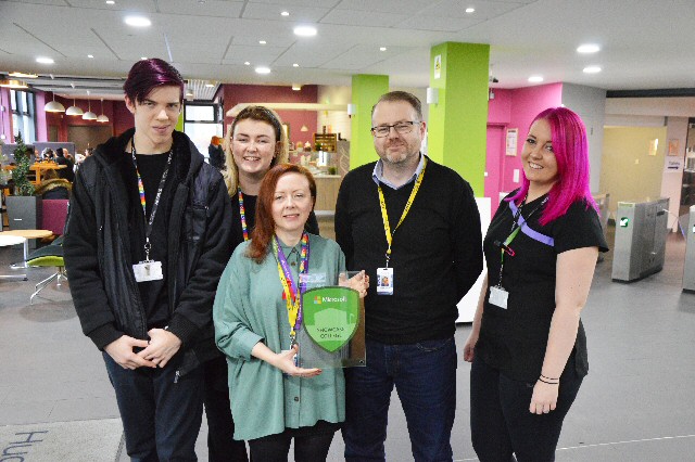 Hugh Baird College students and John Billington, Head of Services and Nicky Bowen, E-Learning and Training Officer, with the Microsoft Showcase College plaque.