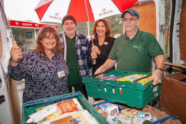 South Liverpool Foodbank's Nicola Hawkes, Billy Breden and Phil Keating collect a food parcel from Redrow's Helen Pirie