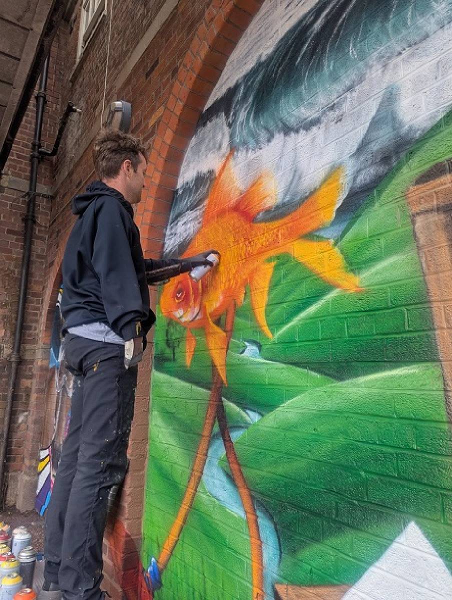John Culshaw painting mural at Dovecot Parade.